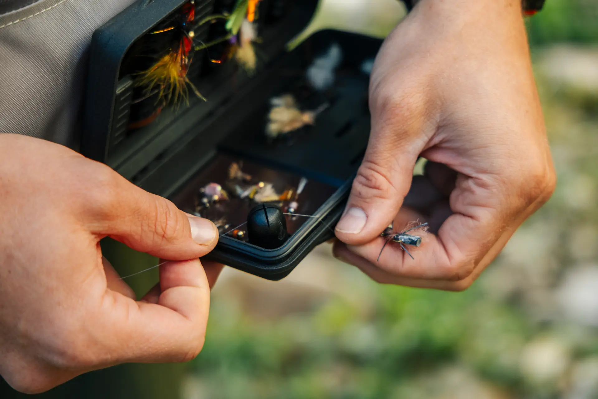 Angler selecting a fly from the QuickDraw Magnetic Fly Box